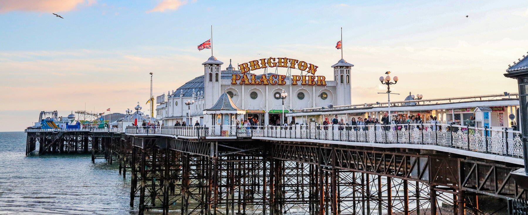 Brighton Palace Pier at sunset, its stalls and amusements lit up over the sea - the finish of the London to Brighton ride