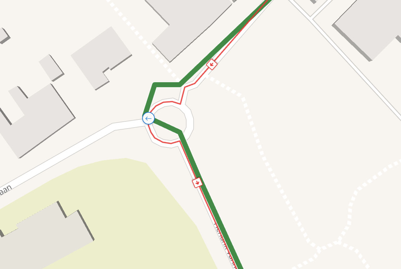 The same roundabout after the fix. The thin red matched line now follows the green one the long way round the west side, along the road