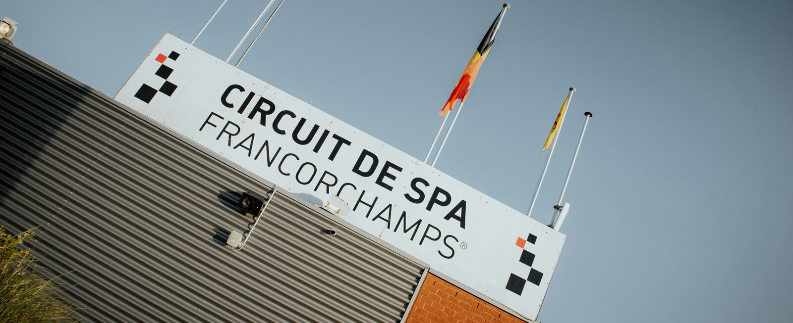 Spa-Francorchamps: 7.004 km of the best racetrack on Earth, and this weekend it's Grand Prix time The Circuit de Spa-Francorchamps entrance sign with a Belgian flag flying
